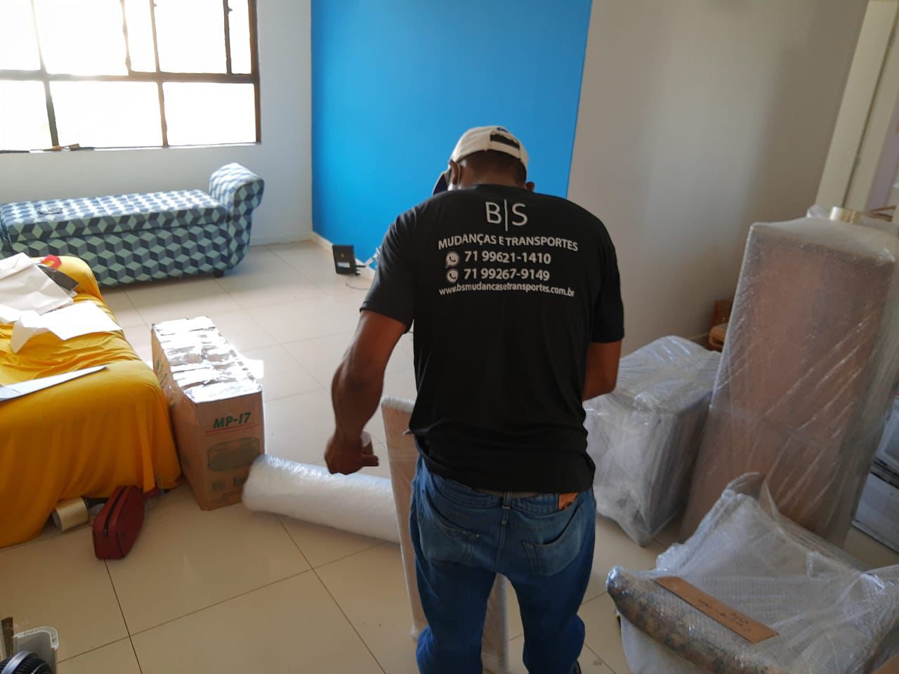 Profissional da BS Mudanças embalando móveis
